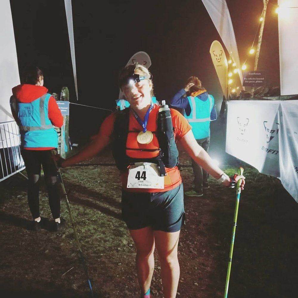 Charlotte finishing The Lap at night with her medal
