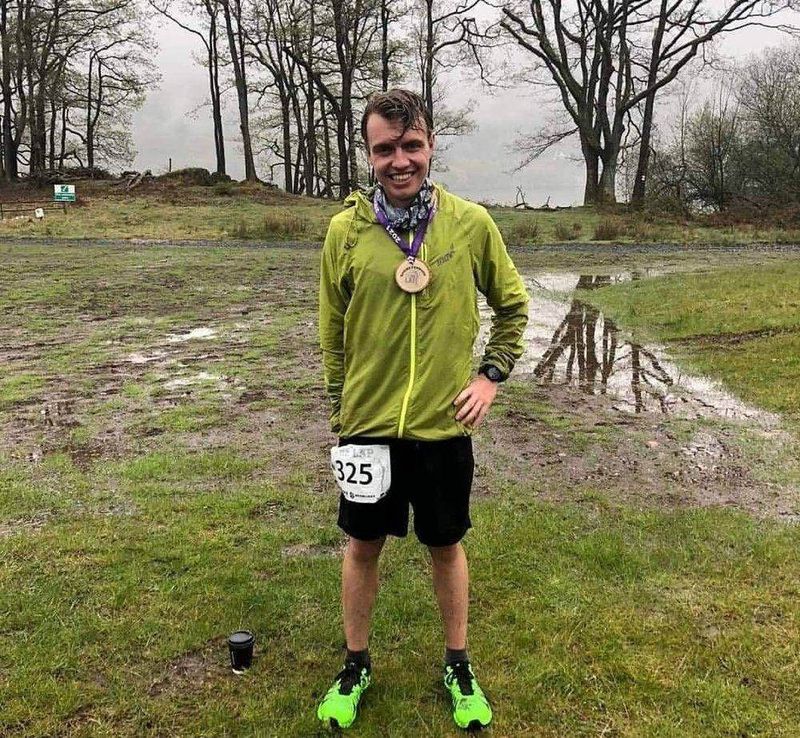 James finishing The Lap with his medal in torrential rain